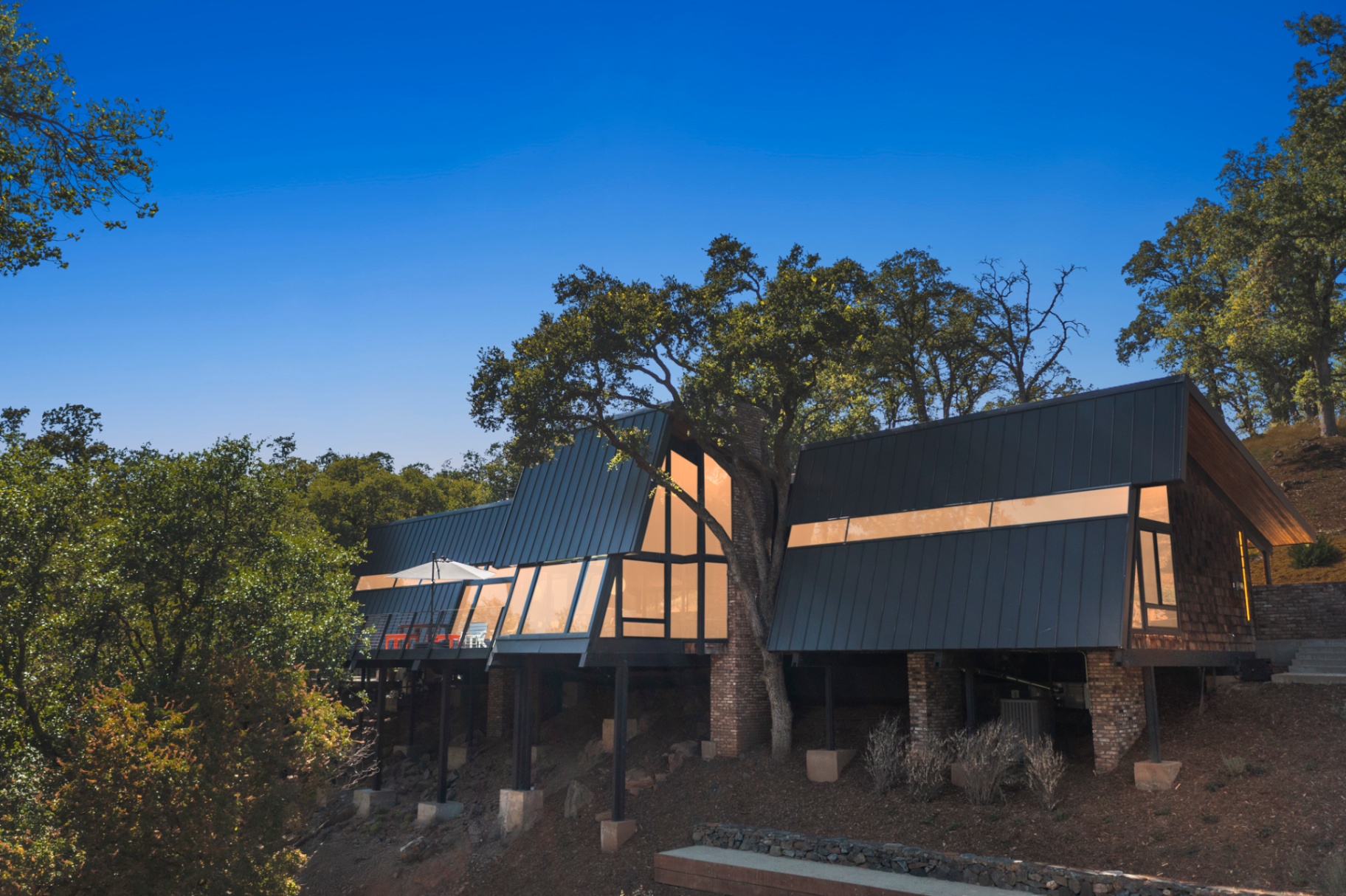 Twilight exterior of the home on its steel-post foundation