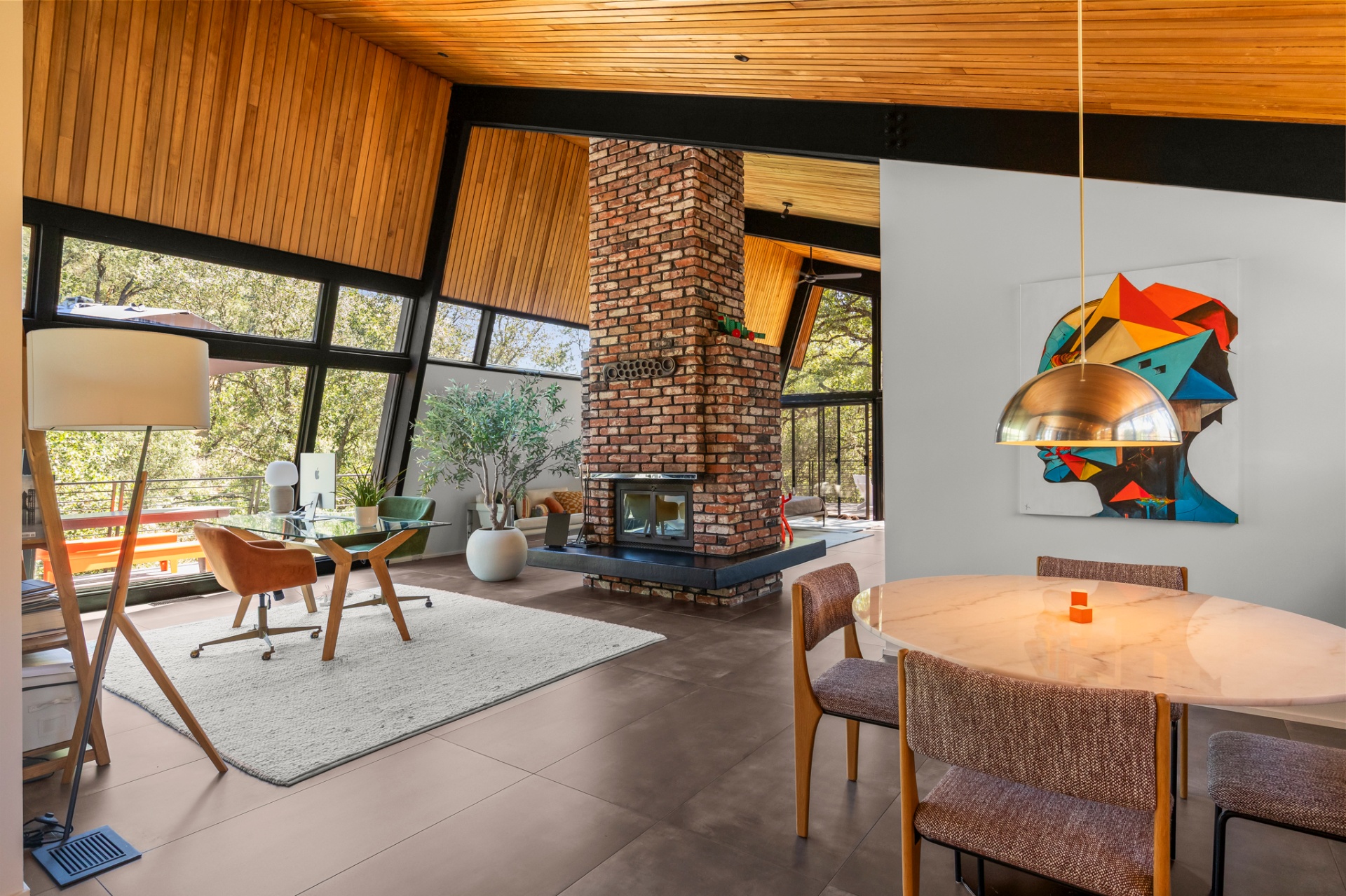 Living area with a two-sided brick fireplace, wood ceiling and glass walls