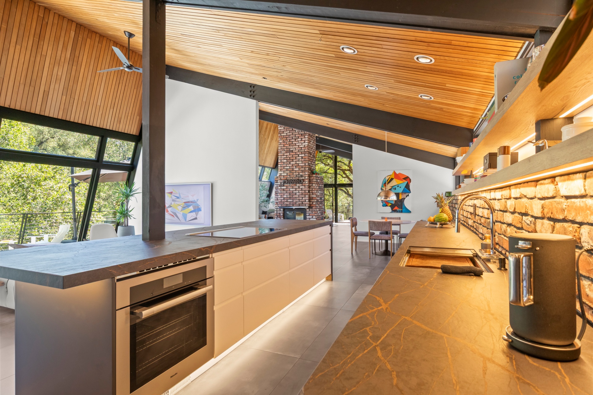 Kitchen with wall oven, stone counters and breakfast nook beyond