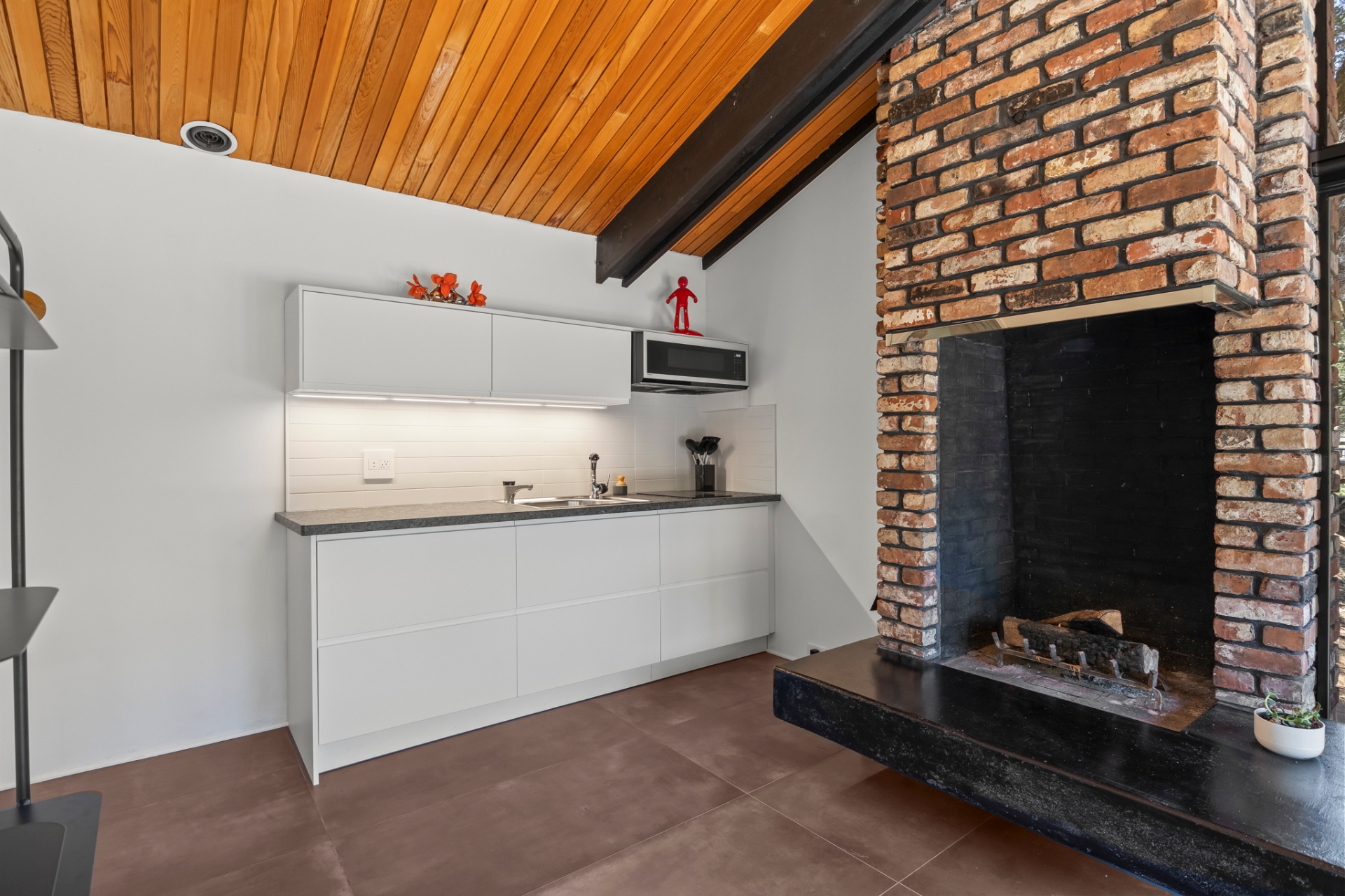 Brick wood-burning fireplace beside the kitchenette