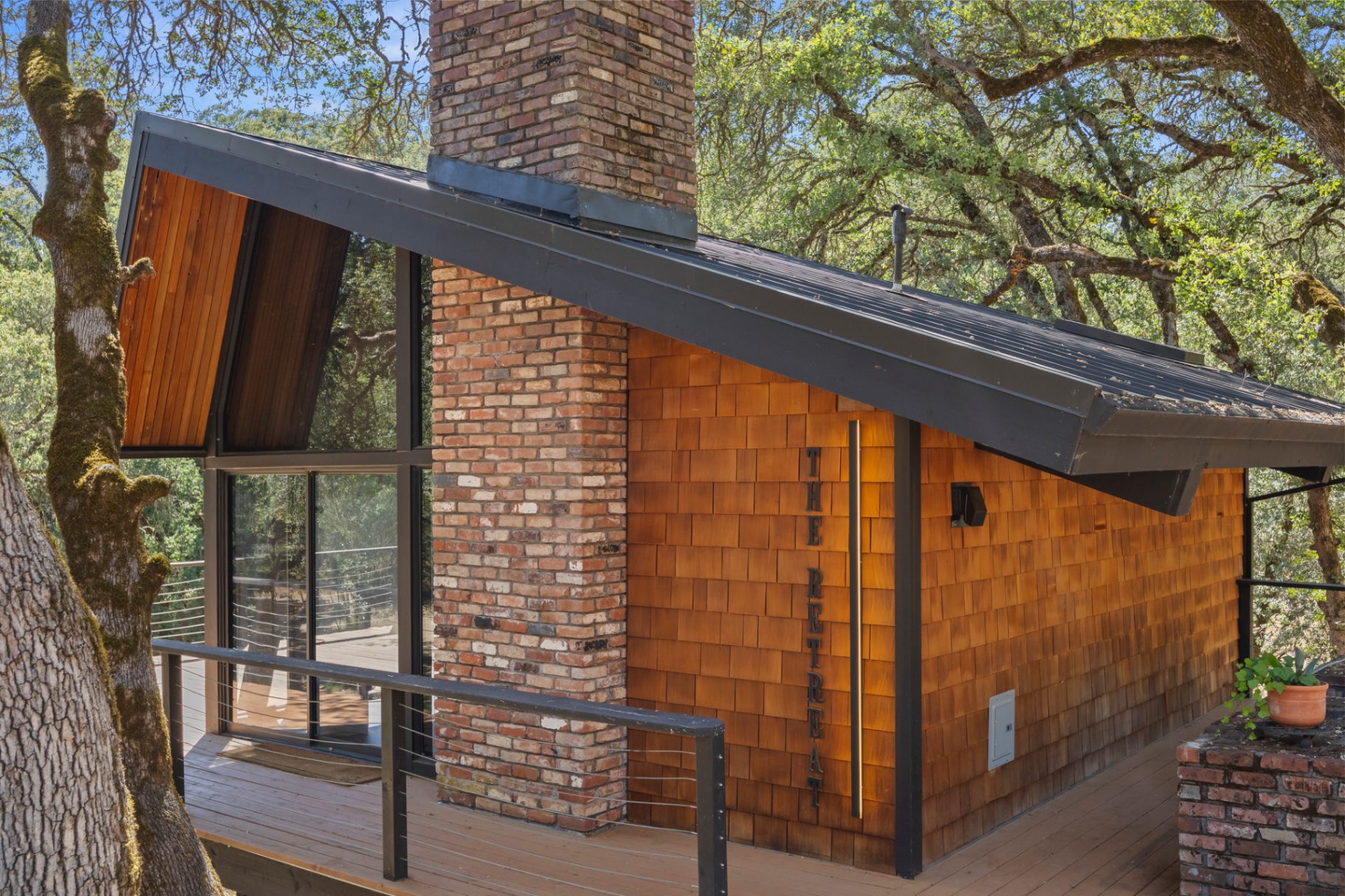 Cedar-shingle guest house with 'The Retreat' signage and brick chimney