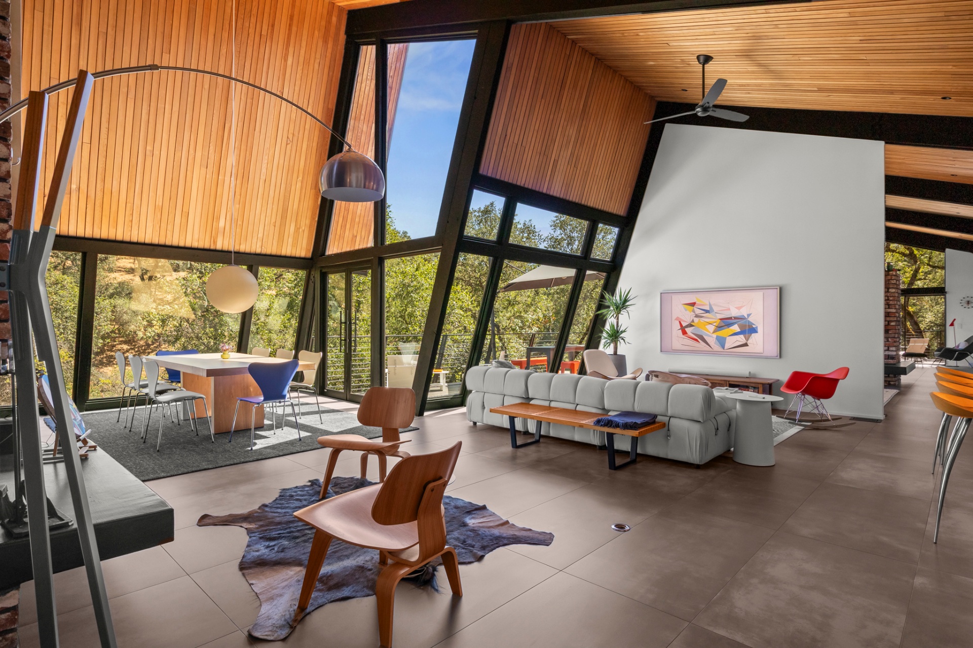 Spacious great room with vaulted wood ceiling, sectional sofa and a wall of windows