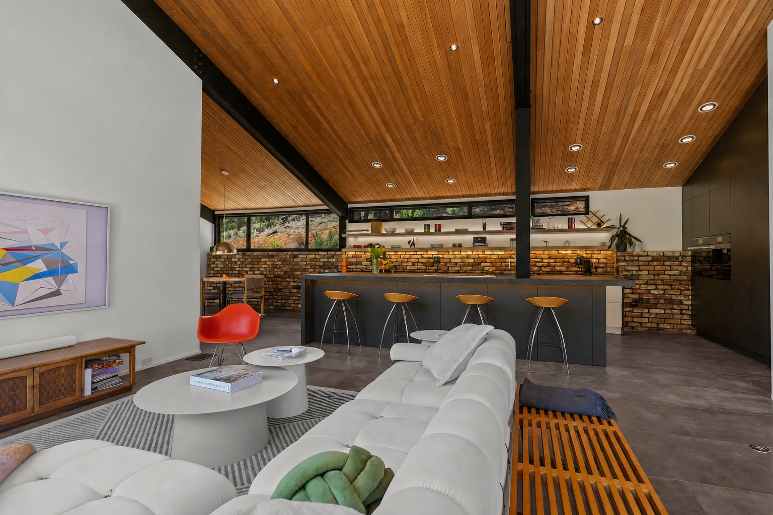 Great room with cedar ceiling, white sectional, kitchen bar and brick backsplash