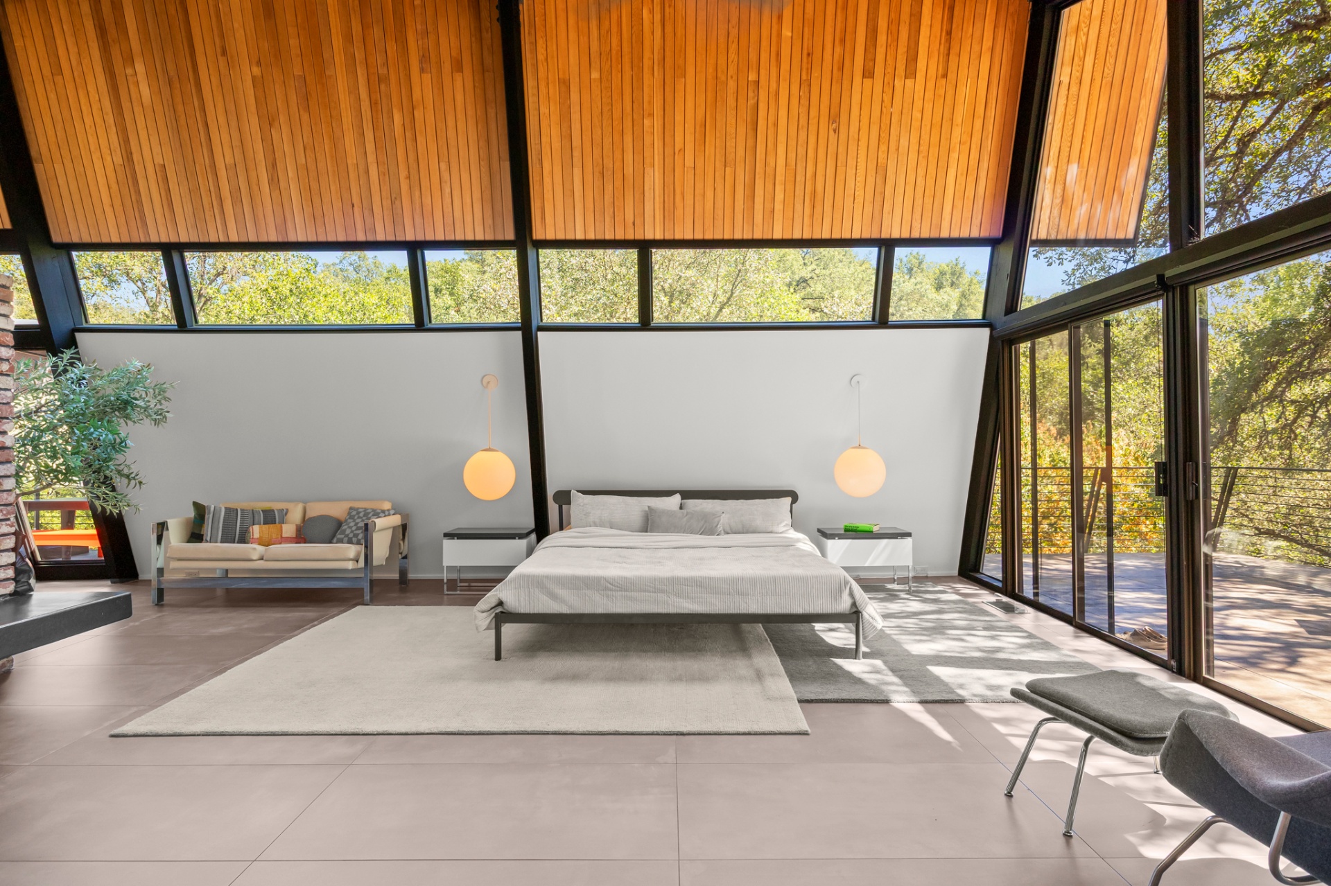 Primary bedroom with wood ceiling, platform bed and walls of windows