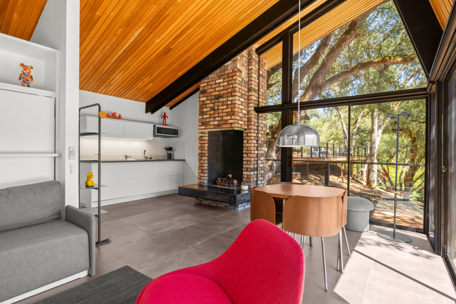 Guest house living room with brick fireplace and vaulted wood ceiling